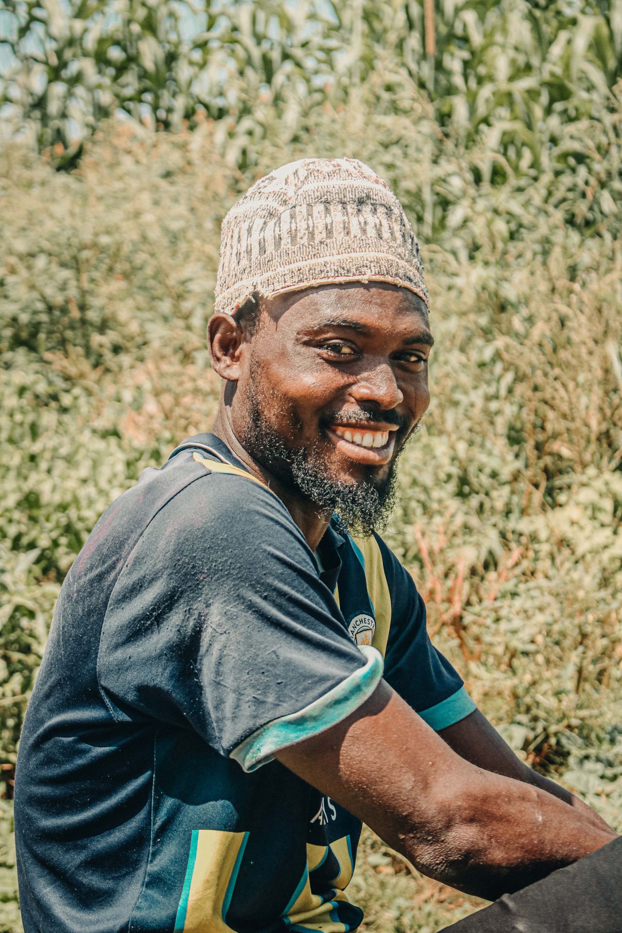 A smiling farmer standing in a Nigerian field